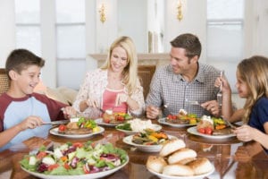 Happy family of four eating dinner around the table Pointe's Pantry Grosse pointe michigan home meal delivery service